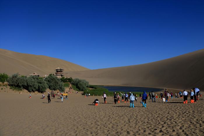 游客在敦煌鸣沙山月牙泉景区游览(2023年6月7日摄)。新华社发(张晓亮摄)