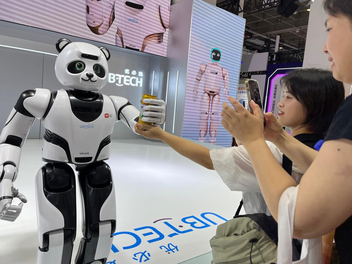 16日,2023世界机器人大会博览会上的熊猫机器人与观众互动.