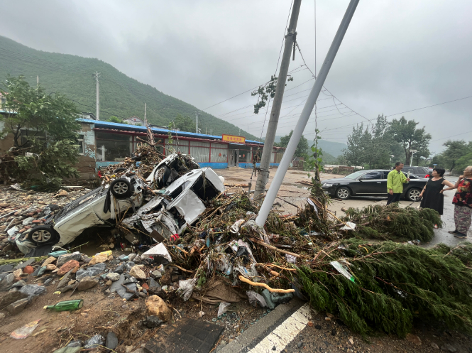 2023年8月1日，门头沟区潭柘寺镇平原村附近，路旁有被水冲毁的汽车和倒伏的树木。新京报记者 丛之翔 摄
