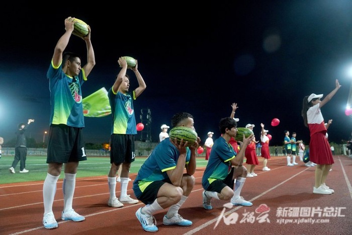 8月15日，在焉耆县第四中学的体育场上，这支队伍抱着西瓜入场。石榴云/新疆日报记者 张万德摄