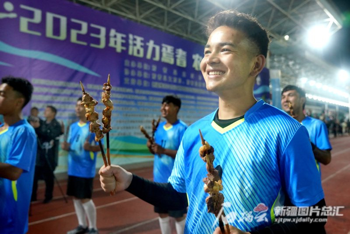 8月15日，在焉耆县第四中学的体育场上，这支队伍每人手持烤肉入场。石榴云/新疆日报记者 张万德摄
