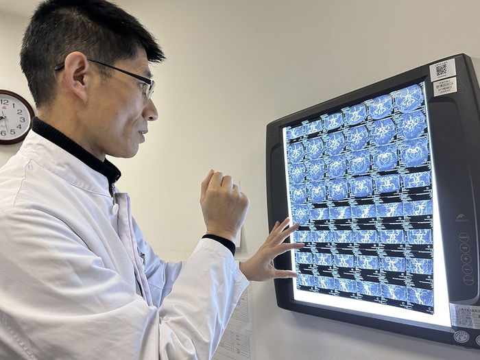 赵开军查看患者检查报告。澎湃新闻记者 李佳蔚 图