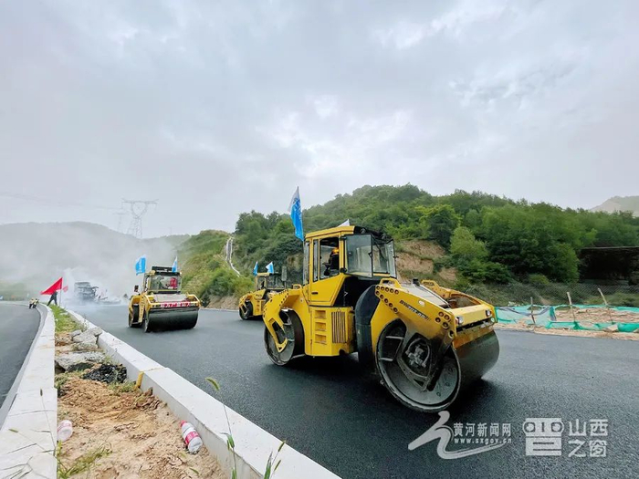 图为数台压路机同时路面施工作业，保障项目如期完工。