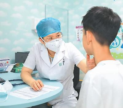 图为王琳在为前来就诊的孩子作检查。 首都儿研所供图