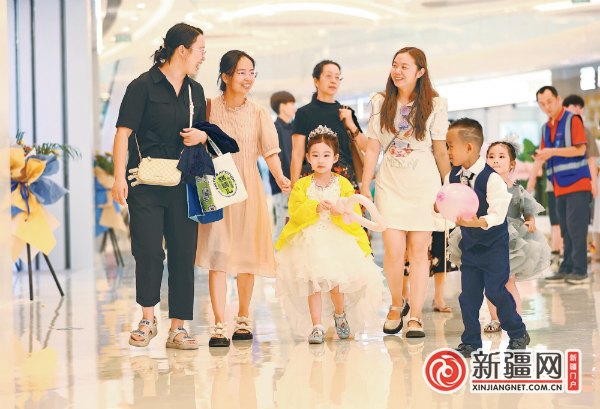 8月25日，水磨沟区会展吾悦广场开业，市民带着孩子到商场参观“打卡”。（全媒体记者石磊摄）