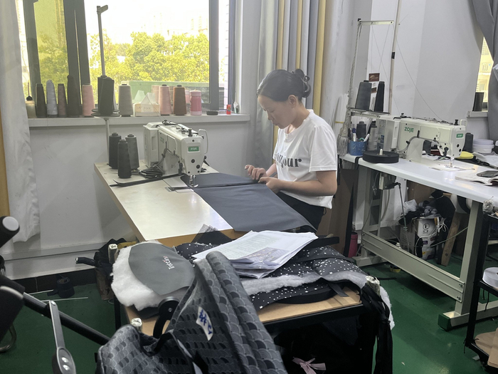 （汉川本地企业车间女工缝纫童车配件布料 吴绵强摄）