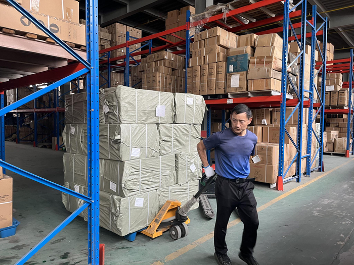（汉川本地童车工厂仓库 工人正在运输装箱童车 吴绵强摄）