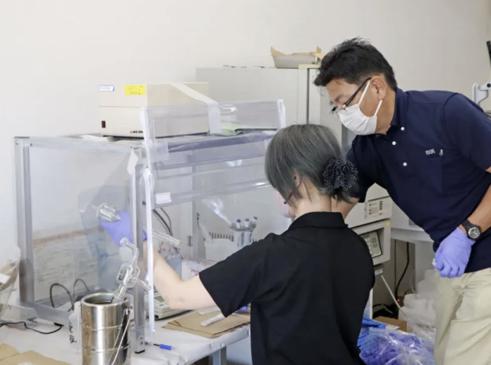 △26日上午对鱼类样本进行检测的工作人员。图源：共同社