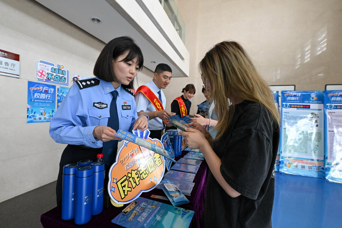 5月23日，民警在天津师范大学指导学生下载反诈App。新华社记者 孙凡越 摄