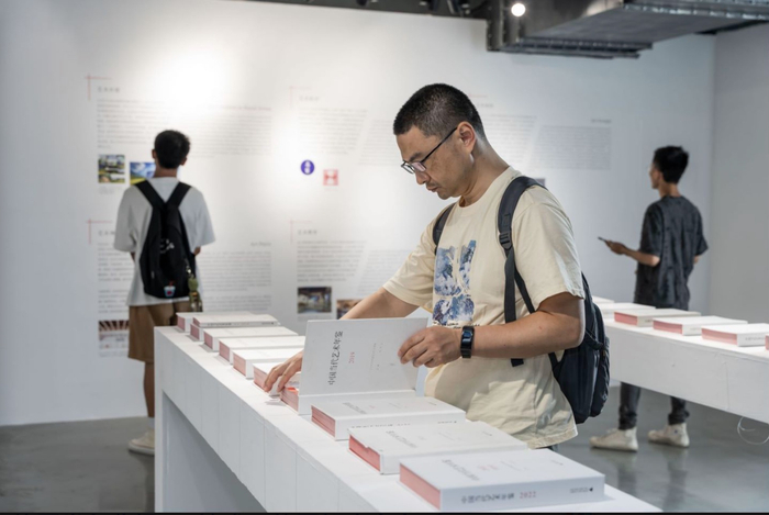 展览现场，观众正在翻阅《年鉴》