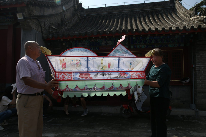 8月16日，人们合力将延庆旱船“三只船”从存放处抬出。新京报记者 尹亚飞 摄