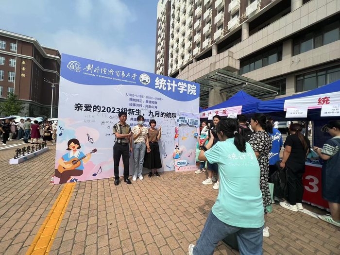 统计学院志愿者为新生及家长拍照留念。新京报记者 罗艳 摄