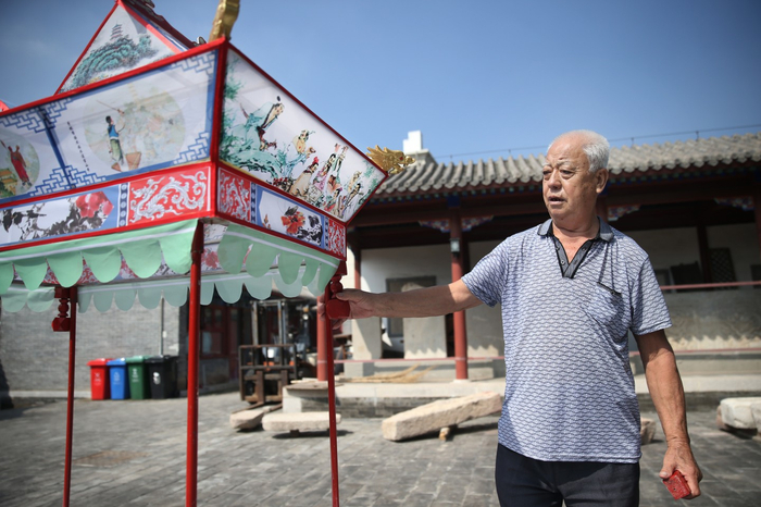 8月16日，丁石锁正在组装延庆旱船“三只船”，船上的十八种彩绘图案是《白蛇传》中的经典场景。新京报记者 尹亚飞 摄