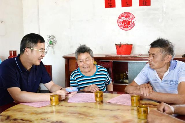 江西省兴国县社保中心负责人在良村镇前村村走访群众，了解养老金领取情况。曾阳 摄