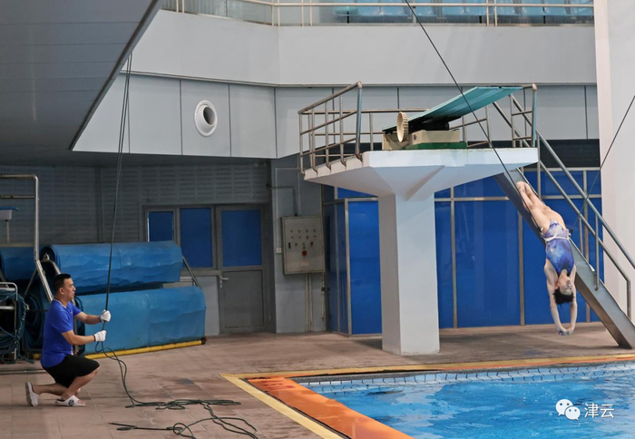 谭良德用绳子辅助运动员进行训练