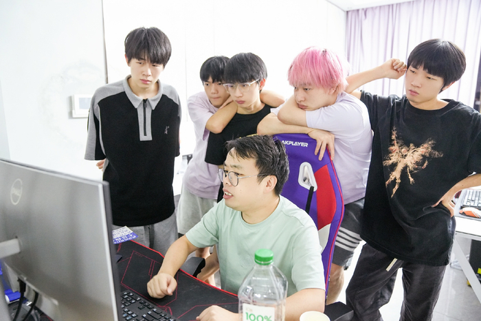 于翔任（后排左一）与队友、教练在训练中复盘比赛。  图/广州TTG