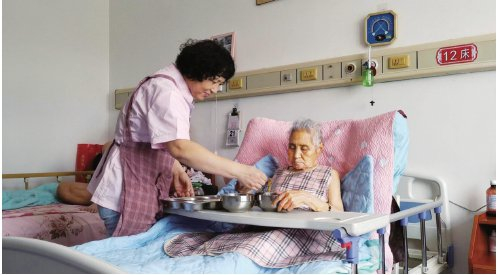 　　8月22日，深州市医院医康养中心护工祝辰香在帮助半失能老人用餐。　资料图