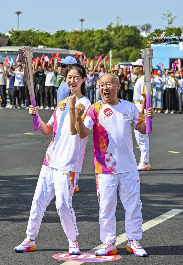9月12日,火炬手崔译文(左)和钱海军在火炬传递中.