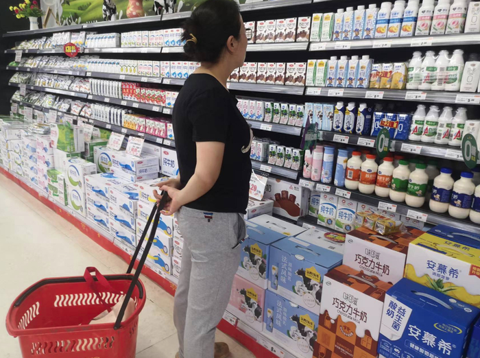 消费者在选购牛奶。  孟刚/摄