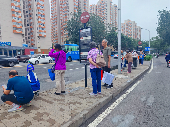 三旗百汇外公交站等公交车的老人