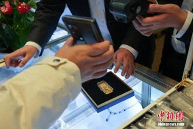 △资料图：顾客在现场扫码购买冰雪竞技金条。中新社记者 崔楠 摄