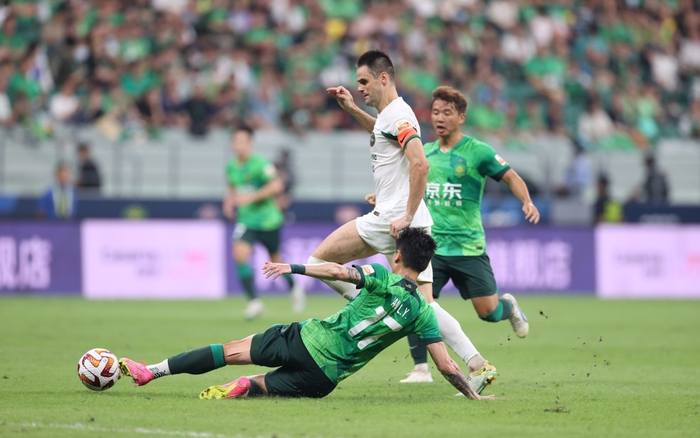 杨立瑜(前)在比赛中铲球. 新京报记者 王飞 摄