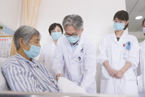             马雄教授（右）在查房，了解患者康复情况  受访者提供          