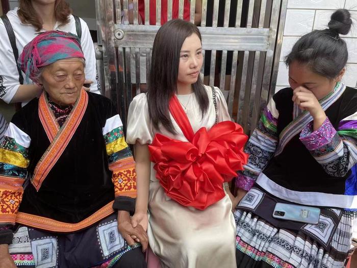 2021年5月15日，杨妞花（中）回到家乡，与外婆（左）、堂妹（右）坐在一起。 新京报记者 彭冲 摄
