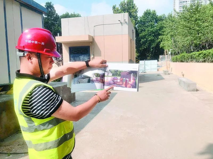 施工人员介绍省体育局家属院即将建成的集中晾晒区 