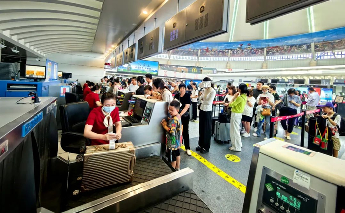 鄂尔多斯机场航站楼内，旅客排队办理值机手续