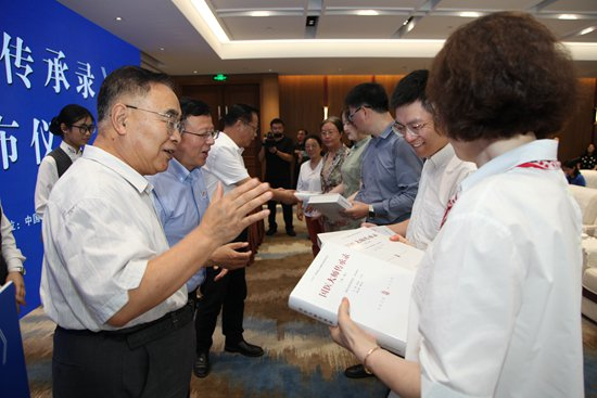     中国工程院院士、国医大师张伯礼等向国医大师工作室代表赠书。受访者供图