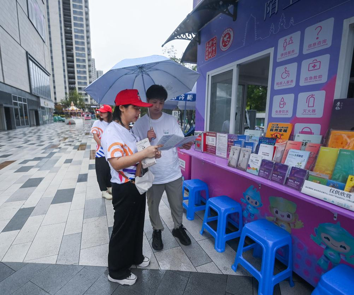 9月15日，志愿者在临安体育文化会展中心体育馆旁的亚运城市志愿服务文明驿站工作。 新华社记者 徐昱 摄