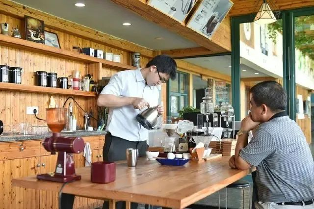       在东莞洪梅镇的咖啡工厂里，吴森胜（左）亲手为父亲吴妙根制作咖啡。新华社记者 梁旭/摄