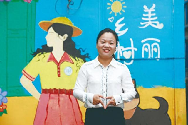朱霞和她手绘的乡村振兴主题文化墙。
