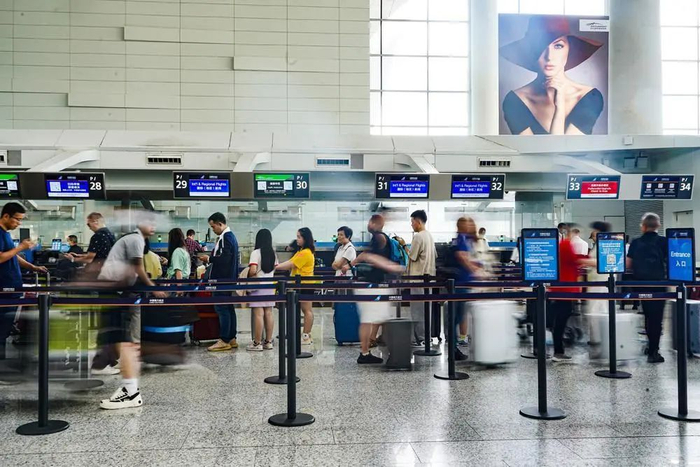 广州白云国际机场内，乘坐国际（地区）航线的旅客排起长龙等待出发