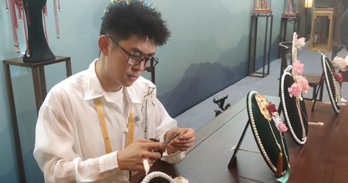 在"好客山东 好品山东"推介会上,90后国潮设计师王平的展位前挤满了人