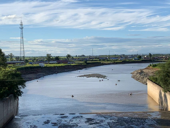 龙凤山水库下，人们划着橡胶圈捞鱼。高佳摄