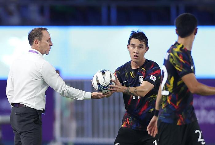 　　10月1日，中国队主教练久尔杰维奇（左）在比赛中将球交给韩国队球员。新华社记者 贾浩成 摄
