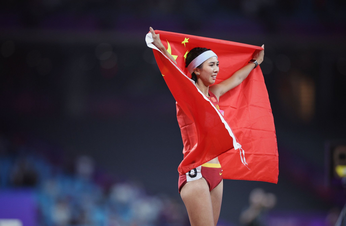 林雨薇披着国旗庆祝夺冠。  新京报记者 薛珺 摄
