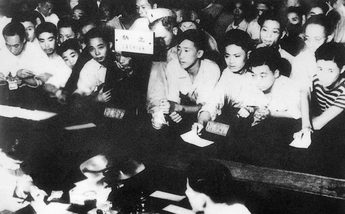 1948年11月10日，上海中央银行柜台前的挤满兑换金圆券的人们。