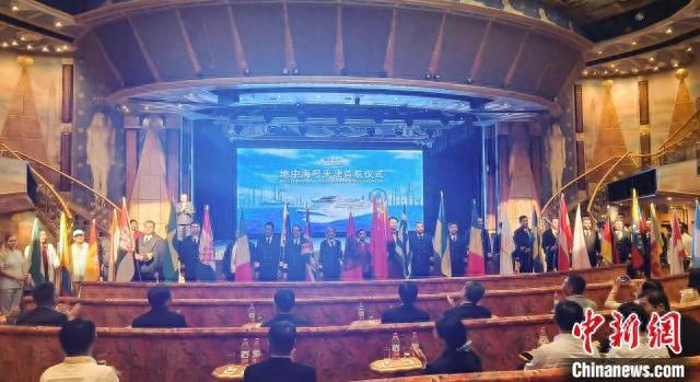 9月27日，地中海号邮轮首行仪式上，各国船员手持国旗入场与游客见面。中新社记者 王君妍 摄