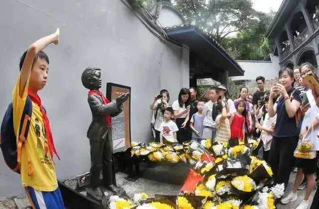 ▲10月1日，白公馆，游客们在小萝卜头塑像前献花拍照纪念。特约摄影 钟志兵／视觉重庆