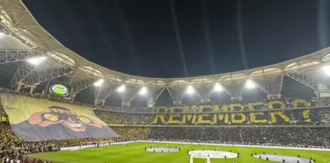模仿的是多特蒙德的著名tifo,在看台上打出了一个笑着举着望远镜的