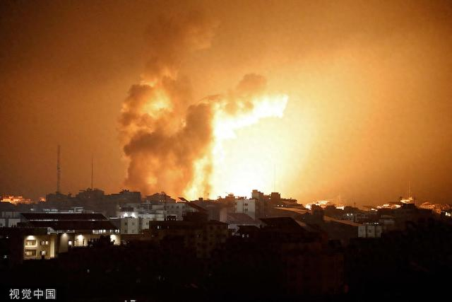 当地时间10月8日，加沙城，以色列发动空袭，大火和烟雾从建筑物上方升起。图片来源：视觉中国 