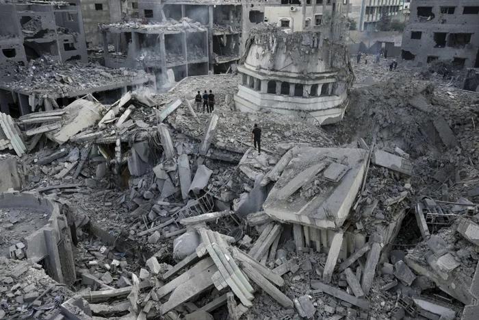 当地时间10月9日，巴勒斯坦人在加沙城亚辛清真寺的废墟中搜寻，该建筑在以色列的空袭中被摧毁。图源：视觉中国