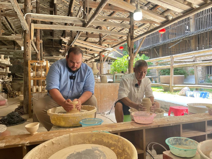 图为非遗传承人宗鸿新教外国游客拉坯。新华社记者 朱雨诺 摄