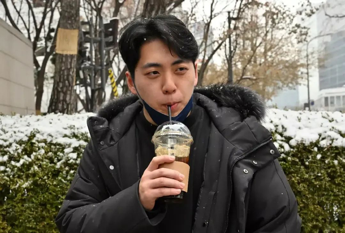 〓 韩国街头喝冰美式的男生（图源：法新社）