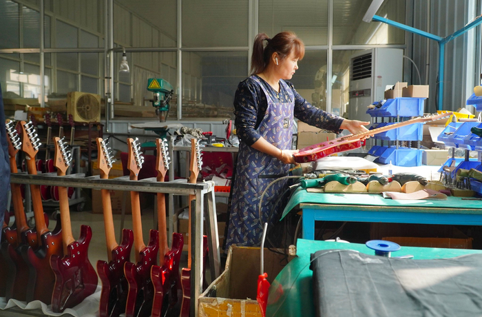 10月17日,在山东省昌乐县鄌郚镇的一家乐器生产企业,一名工作人员在