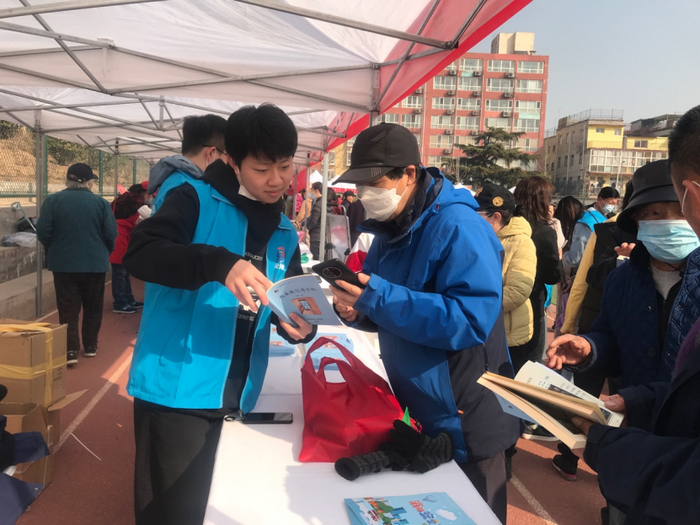 柳昱辰向老人介绍自己制作的手册