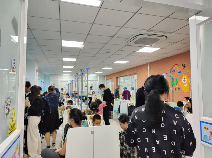 ▲2023年10月14日，首都儿科研究所附属儿童医院的输液区也人满为患，有的家长带着孩子在走廊里坐着。新京报记者 汪畅 摄